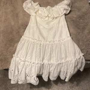 Klänning - Vit klänning med mönster den är ribbad där bak och är lite liten för din storlek. Vi kan även komma överens över ett pris