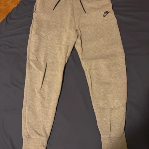 Nike tech byxor  - Gråa Nike tech byxor🤩 Oandvända👌 Nypris 1249kr. Pris går att diskutera vid snabb affär!  För fler bilder, tveka inte, kontakta!!😁