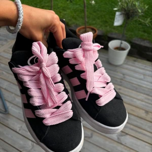 Svarta campus 00 med rosa snören  - Säljer nu mina CAMPUS 00S "CORE BLACK TRUE PINK" pågrund av att de inte kommer till användning. Använda max 5 gånger så skicket är nästan som nytt. Finns även svarta skosnören om man vill byta!
