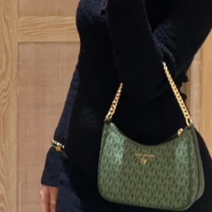 Michael kors jet charm chain pouchette - Liten Michael kors väska i grön. Nyskick, använd fåtal gånger. Köpt på Michael kors i London. 