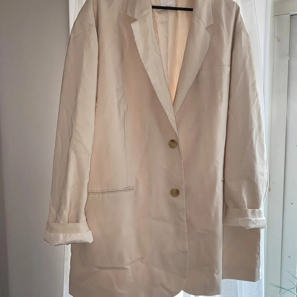 Beige oversize kavaj från H&M.  Säljs inte längre. Nypris 599:- Oanvänd men råka få bort prislappen.  Extra knapp medföljer.  Inget att anmärka på. . Kostymer.