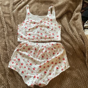 Pyjamas set  - Vitt pyjamas set med röd/rosa blommor , finns ingen lapp men passar som M