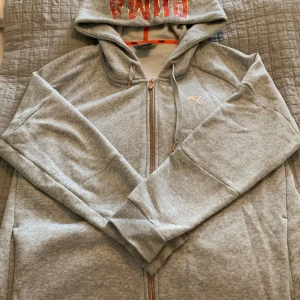 Hoodie dam Puma - Oanväd hoodie i vid modell med logo och tryck i roseguld. Stl 46