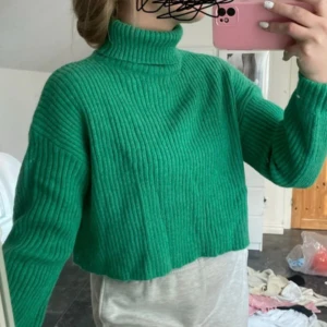Grön ribbad polotröja - Säljer en superfin grön ribbad polotröja som är croppad och perfekt för höst och vinter. Den har långa ärmar och en mysig polokrage. Perfekt för att hålla sig varm och stilren! 💚