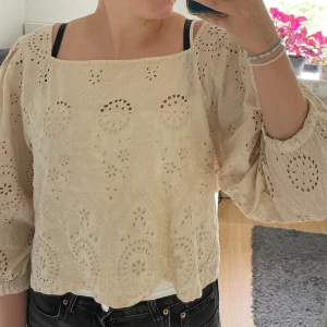 Beige blus från Lindex - Säljer en superfin beige blus från Lindex i storlek L men passar också mig som är M. Den är gjord av 100% bomull och har ett vackert broderat mönster. Blusen har trekvartsärmar och en lös passform. Den är i nyskick.