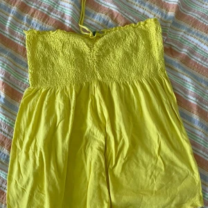 Gul topp från E-vie - Säljer en superfin gul topp från E-vie. Den är axelbandslös med smockdetaljer upptill och har en härlig sommarkänsla. Perfekt för soliga dagar eller en sommarfest! 💛