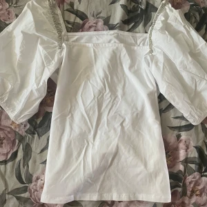 Tröja - Vit tröja som är stretchiga men armarna är som en blus. Dom har fina diamanter på armarna och till och med på vallistan som man ser på andra bilderna. I storlek S från H&M