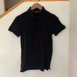 J Lindeberg piké - svart - Säljer nu denna piké från märket J Lindeberg i färgen svart och storlek XS. Skicket är bra. Priset kan diskuteras vid snabb och smidig affär!