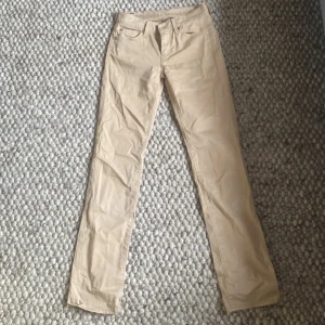 Beige byxor från 7 for All Mankind - Säljer ett par snygga beige byxor från 7 for All Mankind. De är i en slim passform och är Low waist. Byxorna är i ett mjukt och stretchigt material som gör dem superbekväma att ha på sig.använt en gång