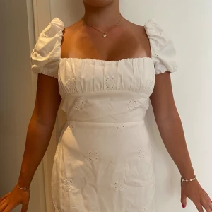 Vit sommarklänning  - Vit kort sommarklänning med broderat mönster Snörning i ryggen. Nästan aldrig använd, bra skick Puffig arm 