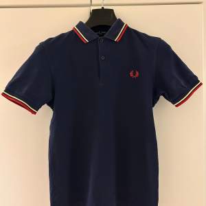 Fräsch och stilren Fred Perry pikétröja i storlek XS. Passar dig som är 170-180cm. Sparsamt använt i mycket gott skick.