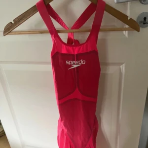 Rosa baddräkt från Speedo - Säljer en snygg och sportig rosa baddräkt från Speedo ❤️Köpt för nästan 6000 kr under en simtävling! Passar perfekt storlek S!! 🫶 Den har en stilren design med korsade axelband och en öppen rygg. Perfekt för simträning eller tävlingar. Materialet är av hög kvalitet och baddräkten är i nytt skick (endast använd 1 gång, sen slutade jag simning😔).. Pris kan absolut diskuteras!🥰