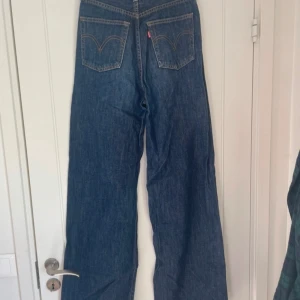 Mörkblåa Ribcage wide led jeans från Levis - Mörkblåa jeans från Levis i storlek 26. Jag skulle säga yta de passar någon som är 160-165 cm. Mycket bra skick.