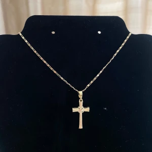 Guldhalsband med korshänge -  ett  guldhalsband med ett korshänge. Halsbandet har en fin kedja och ett detaljerat kors som hänge. Perfekt för både vardag och finare tillfällllen 💓💓