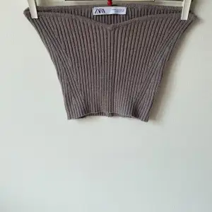 Säljer en superfin beige ribbad tubtopp från Zara. Den är perfekt för sommaren och har en tight passform som sitter snyggt. Toppen är i ett mjukt och stretchigt material, vilket gör den bekväm att bära hela dagen.