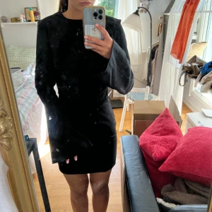 Svart klänning - Svart kort klänning med klockärmar, öppen rygg och små axelvaddar. Knappt använd från H&M.