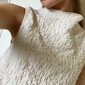 Vit topp från Strandivarius - Vit kortärmad topp från märket strandivarius. Strukturerat tyg, dvs veck, som gör den unik och skitsnygg! Ganska croppad men inte kort!