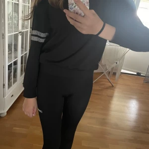 Svart tröja från Stronger - Säljer en svart tröja från Stronger med vita detaljer. Tröjan har långa ärmar och ett tryck med texten 'STRONGER' på bröstet. Perfekt för träning eller en avslappnad dag. Superbekväm och stilren! knappt använd!💓 har lagt upp byxorna i en tidigare annons 😍