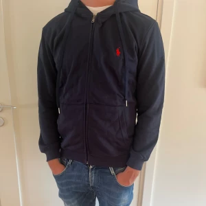 Polo Ralph Louvren zip hoodie - Hej vi säljer nu denna fina zip Hoddie från polo Ralph Louvren som är i väldigt fint skick |  storlek M | modellen är 181 cm och väger ca 75 kg | Säljs nu för endast 699kr! | vid mer funderingar så äre ba å höra av sig🤩⭐️ 