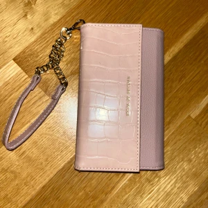 Ideal of Sweden mobilskal + plånboks fodral iPhone 11 - Ett svart mobilskal och ett rosa plånboksfodral från ideal of Sweden. Mobilskalet sätts på plånboksfodralt enkelt genom en inbyggd magnet, det är lika lätta att få av den som det är att få på den. Skalet och plånboksfodralet passar iPhone 11💕