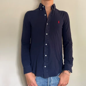 Mörkblå skjorta från Ralph Lauren - Säljer denna assnygga skjorta från Ralph lauren av det sköna featherweight materialet, skicket är 7/10 . Skriv om ni har några funderingar!