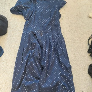 Klänning  - Blå Klänning med prickar och knappar, fint skick! Är 6XL men känns mindre