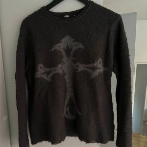 Stickad tröja med kors - Hej säljer denna stickade tröja från Jaded London, tröjan är endast använd en gång därav väldigt bra skick! 