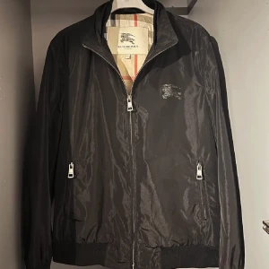 Burberry Jacka - Svart Burberry jacka, kan inte vända sig ut och in, har aldrig använts innan och är i bra skicka. Storlek M men passar mindre. Kontakta för fler frågor.