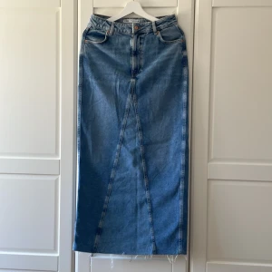 Lång jeanskjol från Zara i strl S - Lång jeanskjol från Zara i strl S med hög slits bak så går bra att gå i. Går till marken på mig som är 168 cm. Mycket fint skick, i princip oanvänd.