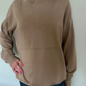 Beige hoodie från Lindex - Säljer en beige hoodie från Lindex. Den har en stor ficka på magen och texten 'Today/Tomorrow' längst ner. Perfekt för höst och vinter, och den är i nyskick, utom att texten längst ned lossnat lite. skriv för fler frågor eller bilder💞