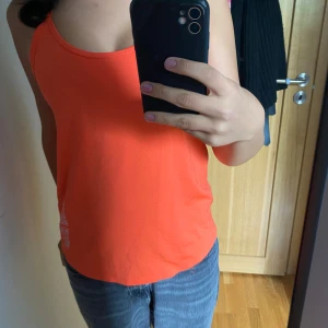 Träningslinne  - Oanvänt neonorange träningslinne, väldigt tunt och lätt tyg. Öppen rygg. 