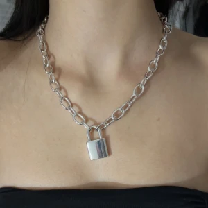 Halsband - Ett silver kedja halsband med ett lås på. Original pris: 250kr