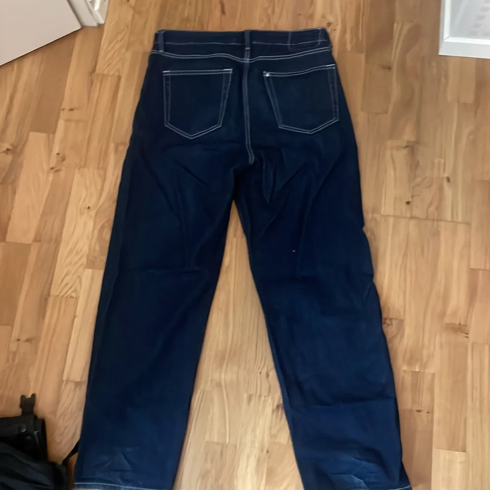 Säljer ett par mörkblå jeans från H&M i loose fit. De är i bra skick och perfekta för en avslappnad stil. Jeansen har klassiska fem fickor och en bekväm passform.. Jeans & Byxor.