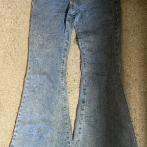 Blå bootcut jeans - Säljer ett par snygga blå bootcut jeans i storlek S. De har en klassisk design med en lätt utsvängd stil som ger en retro känsla. Perfekta för både vardag och fest!
