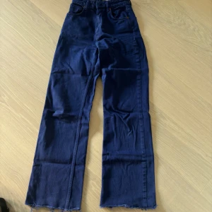 Blåa jeans från zara - Säljer mina blåa jeans från Zara. Byxorna är högmidjade, vida ben och är i storlek 34. De är endast använda en gång och är avklippta lite i benen då de var väldigt långa.  Pris: 100kr plus frakt