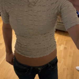 Beige Kort topp - Stl:xs En kort topp med texturerad trikå. 