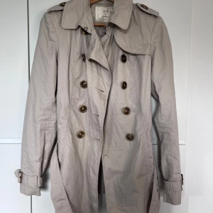 trenchcoat - perfekt höstjacka, lagom varm. 80 cm från axel till nederkant. köpt secondhand men oanvänd av mig 