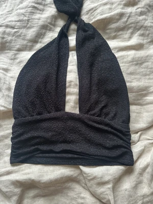 Glitrig topp - En glitrig svart topp i storlek m från cider 