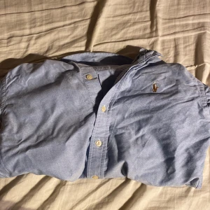 Säljer blå ralph lauren skjorta - Säljer skjortan för den är för liten för mig och har ingen användning för den längre