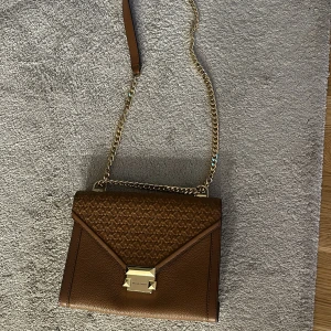 En äkta michael kors väska i färgen brun kedja guld - En brun äkta Michael kors väska med guld kedja, Bra fickor inne i väskan 