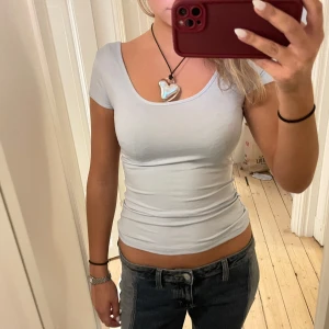 Tajt tshirt med urringning  - Ljusblå tajt tshirt med urringning! Så fin, lappen är tyvärr borta samt storleken men skulle gissa på att den är s-xs 