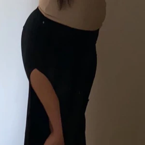 Kjol  - Svart kjol köpt från spanien. Rynkad vid sidan där det är öppet. Stretchig 