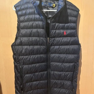  Polo Ralph Lauren väst - Säljer en snygg svart dunväst från Polo Ralph Lauren i fint skick. Storlek S men stor i storleken så passar M. Självklart äkta. Nypris 3295kr priset är inte hugget i sten.