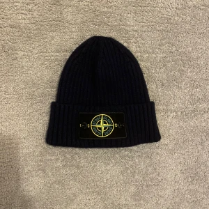 Svart stickad mössa från Stone Island - Säljer nu denna mössa från stone island. Den är mörkblå även om de inte syns så tydligt på bilderna. Perfekt nu till vintern ❄️. Använd endast 2-3 ggr. Kan gå ner i pris vid snabb affär. Skriv vid funderingar.