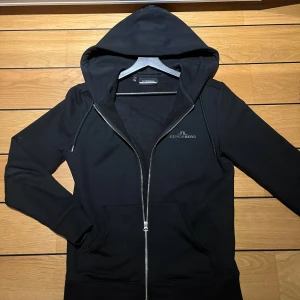  J.Lindeberg - Säljer en stilren svart zip hoodie från J.Lindeberg i mycket bra skick.  Storleken är S och tröjan är i toppskick!