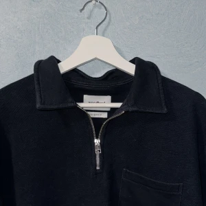 Marinblå Woodbird Half Zip - Jag säljer en riktigt fet marinblå half zip tröja från woodbird. Säljer tröjan eftersom den inte riktigt passar mig. Tröjan är riktigt snygg med väldigt fin dragkedja och bröstficka! Texturen är lite reflig vilket jag tycker är väldigt fint! Skick 9/10. Storlek M