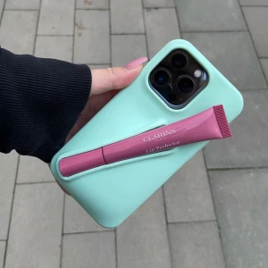 Mobilskal från AMORE UF - Mintgrönt mobilskal med hållare för läppglans från AMORE UF i storlek 13/14/15 i färgen AMORE MINT. Det får plats flera olika läppglans i hållaren och skalet ger bra skydd för mobilen💞💕