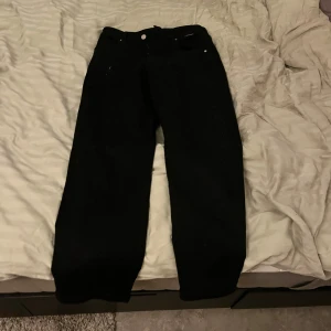 Svarta jeans - Säljer ett par svarta jeans i bra skick. De har en klassisk design med knappar och dragkedja framtill. Perfekta för både vardag och fest! 🖤