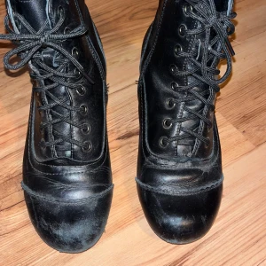 Svarta boots med snörning och dragkedja - Säljer ett par svarta boots i skinn med både snörning och dragkedja på sidan. De har en 4 cm klack och är storlek 27. Väl använda och slitna fram på tårna och på undersidan, men det är inget som påverkar skorna och är annars väldigt fina. Skriv för mer info eller bilder! 💕