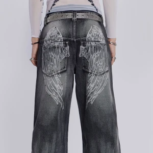 Jaded london jeans - Säljer ett par grå jeans med coolt vingmönster på bakfickorna från jaded london. De har en loose passform och är perfekta för en avslappnad stil. Jeansen har en högmidjad design och är gjorda i denim. Perfekta för höst och vår! Knappt använda, lite slitna där under dock :)